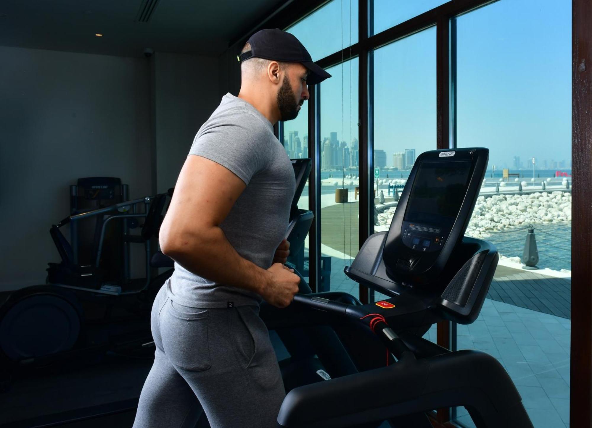Mina Hotel And Residences By The Torch Доха Екстериор снимка A man exercising on a treadmill